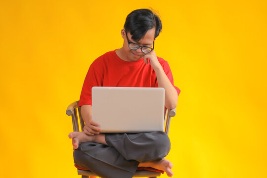 Young Boy Focused on Laptop, Learning and Connecting Online Isolated on Yellow Background - Powered by Adobe