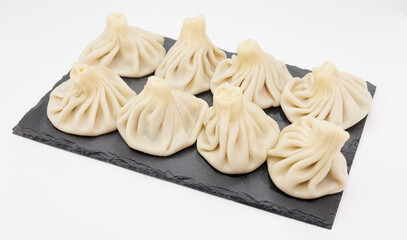 Steamed Georgian Khinkali On Black Slate Platter. Fresh Handcrafted Dumplings For Sharing