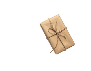 Top-down view of a gift wrapped in brown paper, tied with string, set against black space