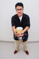 Man standing and holding a cup of hot coffee for breakfast