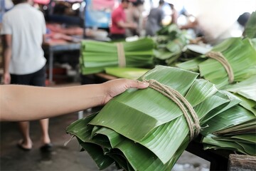 asian wet market scene of buying banana leaves pile
