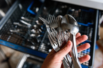 An open dishwasher with clean dishes in the kitchen.