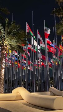 night view of square with waving international flags in doha qatar