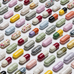 Assorted Colorful Capsules Arranged on White Background – Pharmaceutical Pattern