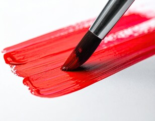 Brushstroke of bright red paint on white surface, close-up