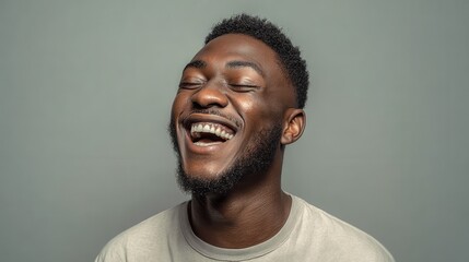 Fototapeta premium handsome unshaven young darkskinned male laughing out loud at funny meme he found on internet smiling broadly showing his white straight teeth positive human facial expressions and emotions no logos 