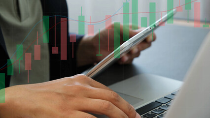 Business person using tablet and laptop with stock market candlestick chart overlay, representing financial analysis, investment strategy, and digital trading technology