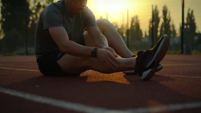 Sports training. A man of European appearance strives for success, he warms up, developing his joints. An athlete in professional equipment develops endurance on a specialized complex