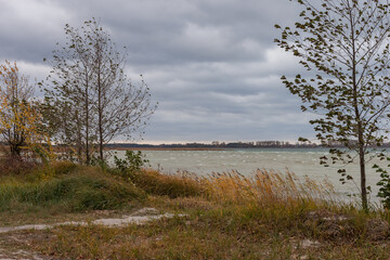 Lake in windy and cloudy weather. Autumn
