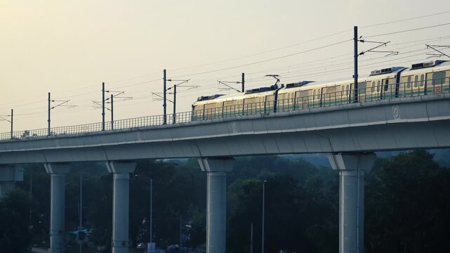 Delhi metro running parallel to highway with moving vehicles