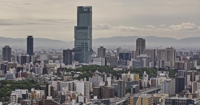 Osaka Japan Aerial v119 zoomed flyover Nipponbashi capturing Abeno Harukas skyscraper and urban cityscape with mountains in the backdrop under a cloudy sky - Shot with Mavic 3 Pro Cine - Oct 10th 2023