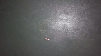 Top-down drone view of white water rafting on the River Nile in Uganda, showing a single raft navigating textured water, globally recognized destination for Grade V rafting, kayaking, and eco-tourism.