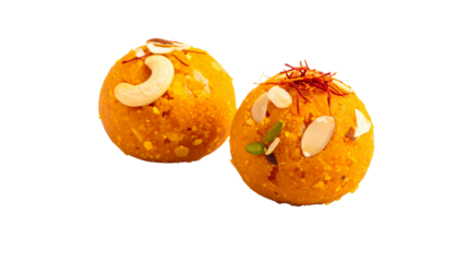 Two traditional Indian orange ladoos with dry fruits isolated on transparent background
