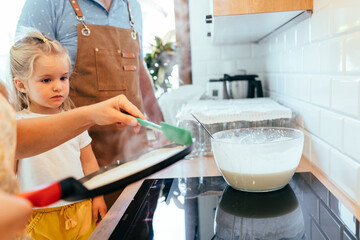 Toddler girl standing in kitchen near parents