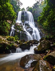 Obraz premium Lush waterfall cascading down rocky terrain