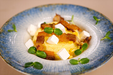 Corn porridge banosh cooked in cream and seasoned with cracklings and brinza cheese. High quality...