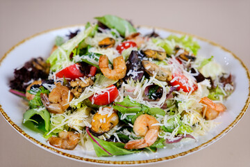 Shrimp salad with avocado, cherry tomatoes, green leaf mix salad and sesame seeds on a white background. Top view. High quality photo
