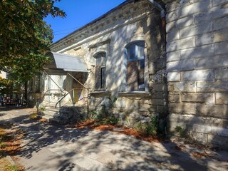Sunlit historic stone building in old city street, vintage architecture composition, heritage urban scene, classic wall texture, shadows and light contrast, ancient facade