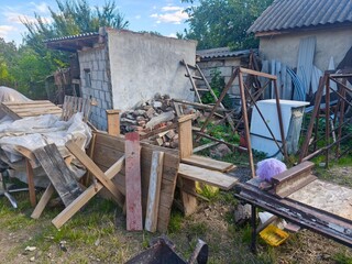 Construction materials and wooden debris stacked near building, renovation site setup, outdoor industrial texture, sunlight and shadow tones, handmade hardware background composition.