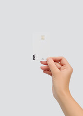 Hand holding a white Visa payment card