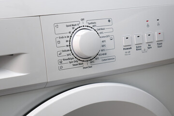 Close-up of the control panel of a modern washing machine white color. Circle selector for choosing the washing mode.