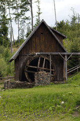 Fototapeta premium Water mill used for gold mining in the mountains. Mill powered by a water wheel breaking gold ore. Gold mining in the mountains.