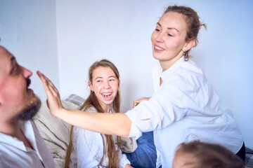 Fototapeta premium a family plays by painting each other's faces with gold glitter during a Christmas party at home