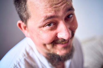 a family plays by painting each other's faces with gold glitter during a Christmas party at home