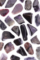 Sugilite rare jewel stones texture on white light background. Sparse mineral pebbles background.