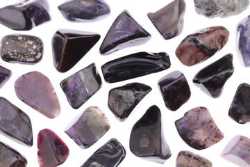 Sugilite rare jewel stones texture on white light background. Sparse mineral pebbles background.