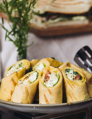 Beautifully decorated banquet catering table, with variety of with different food snacks appetizers on corporate birthday party event or wedding celebration, canape, salad, delicatessen setting