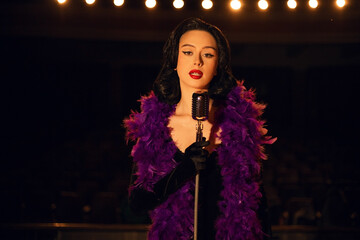 Woman singing on stage in vintage style with a retro microphone and dramatic lighting