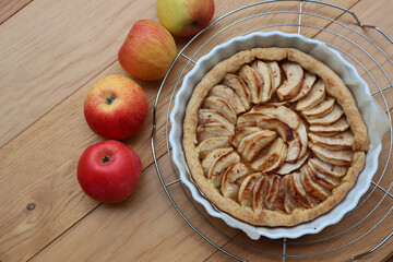 Traditional french cake Tart aux pommes with sliced apples on wooden table