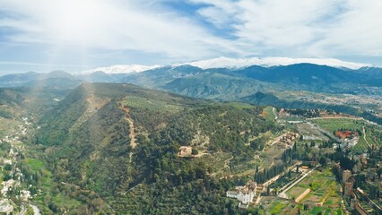 Obraz premium Drone flying aerial view Granada Sierra Nevada mountains landscape green hills blue skyline beautiful nature olive groves historic Alhambra travel Andalusian countryside Spanish tourism destination