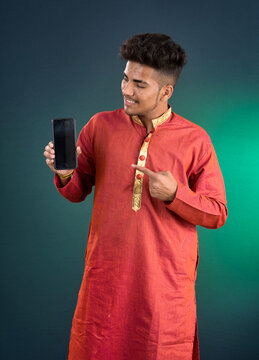 Young handsome traditional man showing a blank screen of a smartphone or mobile phone