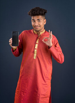 Young handsome traditional man showing a blank screen of a smartphone or mobile phone