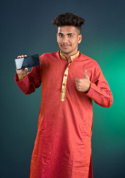 Young handsome traditional man showing a blank screen of a smartphone or mobile phone