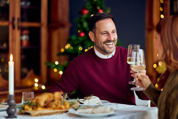 Joyful Couple Toasts With Wine During New Year Dinner At Festive Indoor Celebration