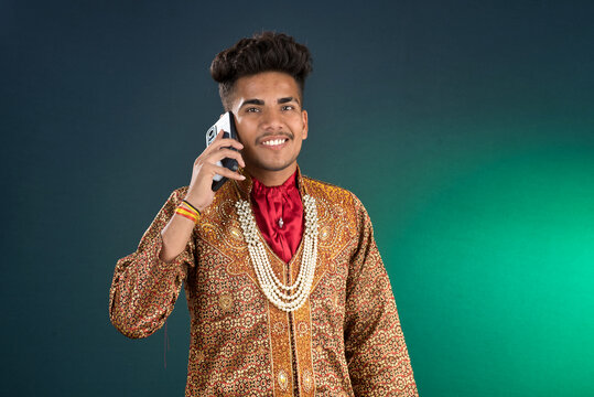 Young handsome man holding and using smartphone or mobile phone