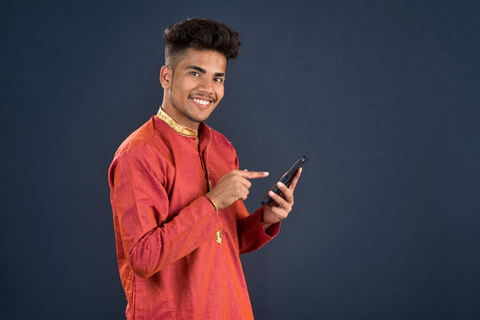 Young handsome man holding and using smartphone or mobile phone