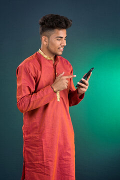 Young handsome man holding and using smartphone or mobile phone