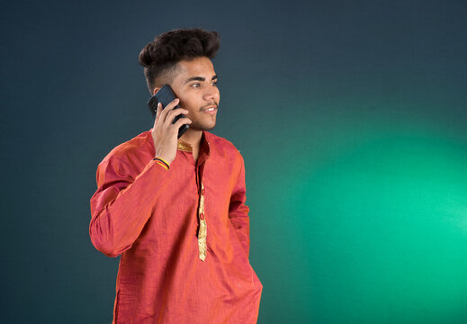 Young handsome man holding and using smartphone or mobile phone