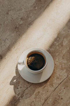 Cup of black coffee on a marble table in a street cafe. Flat lay.