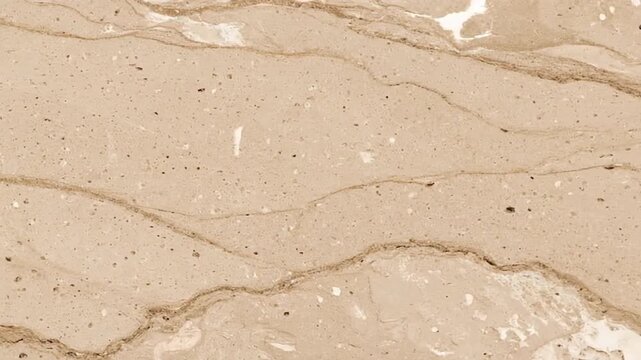 A high-resolution texture of beige or light brown marble with natural veining. A detailed background of a polished stone slab for interior design.