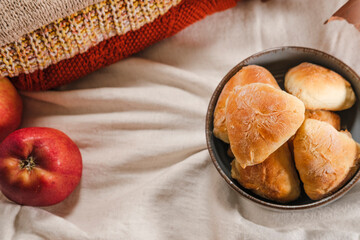 autumn seasonal baking, apple pie pastries, traditional ukrainian bakery, cozy atmosphere with apples, cinnamon sticks, white linen textile, warm tones knitwear