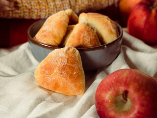 autumn seasonal baking, apple pie pastries, traditional ukrainian bakery, cozy atmosphere with apples, cinnamon sticks, white linen textile, warm tones knitwear