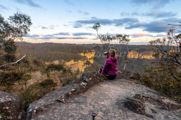 Woman drinks coffee on a cliff in Blue Mountains