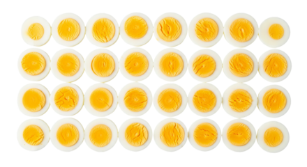 Rows of hard boiled eggs are cut in half exposing the yolk against a isolated background.