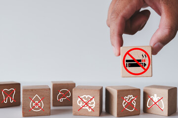 A hand chooses to quit smoking by selecting a 'no smoking' block, a concept for preventing damage to vital organs like the heart,lungs,and brain. A powerful message for a healthy lifestyle,wellness.