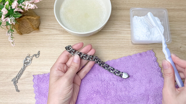 Cleaning silver jewelry with a toothbrush and baking soda, restoring shine and purity to a silver bracelet. Cleaning tarnished silver.